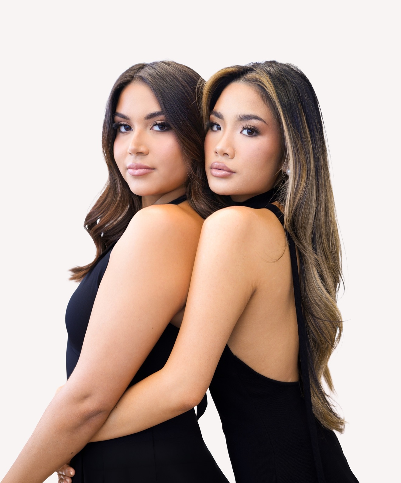 Dos mujeres con vestidos negros, espalda con espalda, mirando por encima del hombro