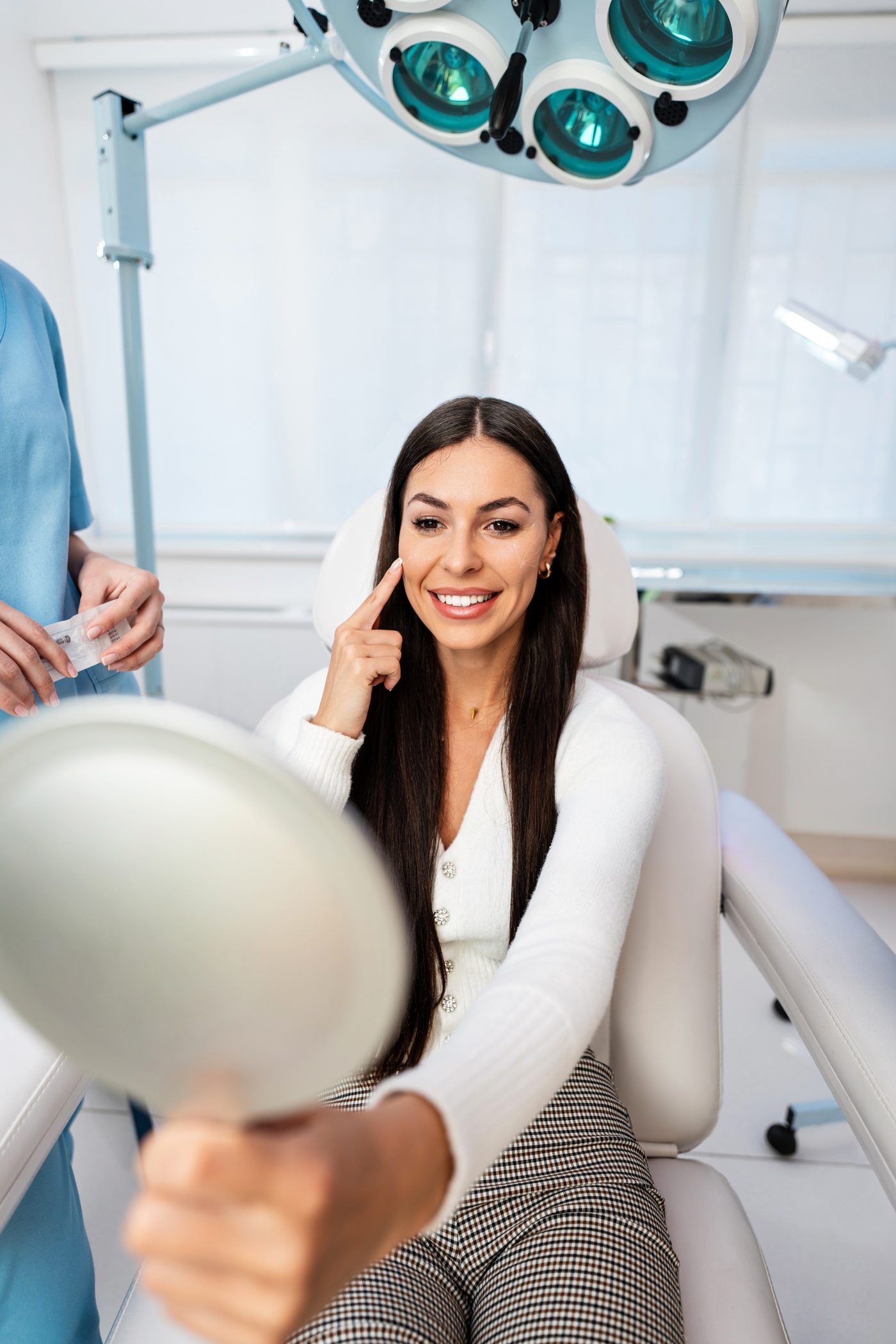 Smiling woman with long dark hair seated in a treatment chair